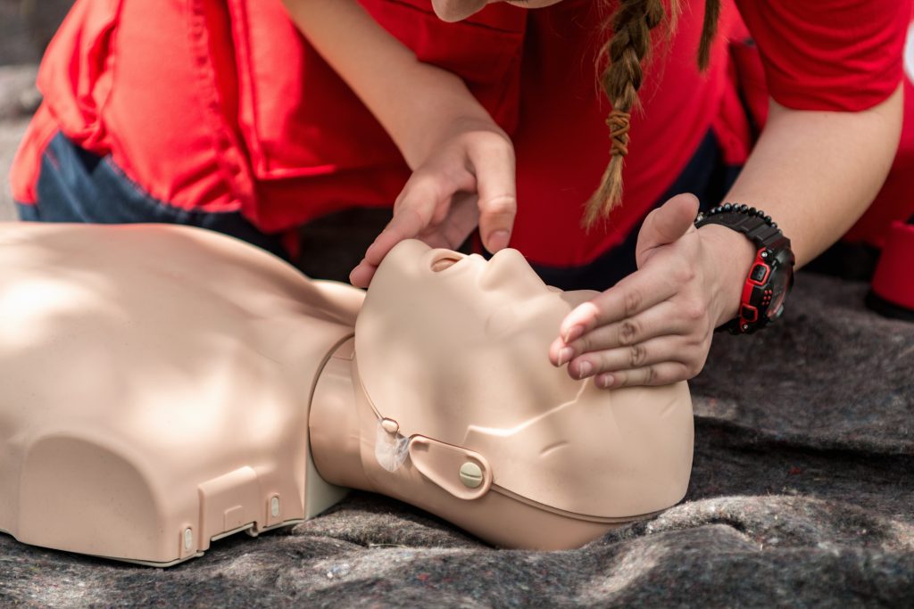 A healthcare provider practices airway management on a CPR mannequin during instructor-led ACLS training.