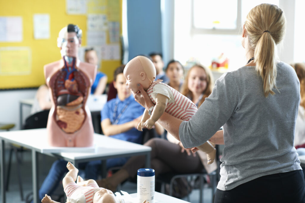 Students learning pediatric airway and CPR skills during PALS certification classroom session