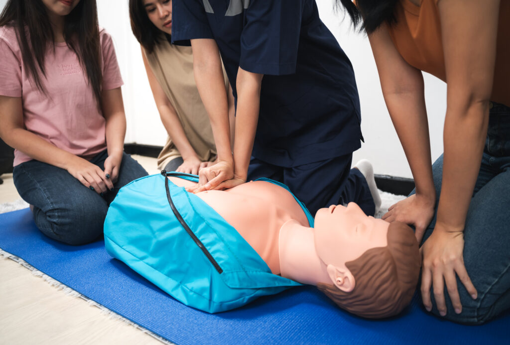 Cardiac Arrest training with healthcare providers performing CPR and advanced life support assessment during emergency simulation